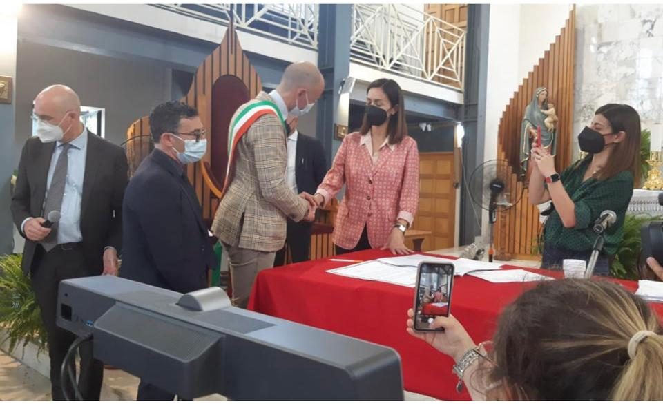 Giornata importante quella di ieri, martedì 7 giugno, per la città di Casoria. Nell’ambito del contratto istituzionale di sviluppo “dalla Terra dei Fuochi al Giardino d’Europa”, è stato firmato il contratto istituzionale per l’ottenimento del finanziamento di circa 3 milioni di euro per il progetto denominato “interventi di rigenerazione urbana tramite l’applicazione riqualificazione di elementi di arredo urbano e di strade comunali” alla presenza di Mara Carfagna, ministra per il Sud e la coesione territoriale. Per l’amministrazione comunale, la firma è stata apposta dall’assessore ai Lavori Pubblici, Luca Brancaccio: “Per me un onore firmare questo contratto istituzionale, un grande risultato per Casoria”, sottolinea l’assessore.Casoria, firmato contratto istituzionale: presente la ministra CarfagnaAlla cerimonia era presente anche don Maurizio Patriciello, da anni impegnato in prima linea nella lotta per la difesa sociale di Caivano e di tutto il territorio tristemente conosciuto come Terra dei fuochi: “Dopo la firma del contratto istituzionale con il ministro Mara Carfagna per un finanziamento di 3 milioni di euro per la città di Casoria ho avuto un piacevole scambio di battute con don Patriciello (dallo scorso aprile sotto scorta, ndr) -prosegue Brancaccio – Dopo avergli rinnovato la mia personale stima e tutto il mio supporto, ci siamo lasciati con tante idee progettuali di legalità anche per la città di Casoria”.